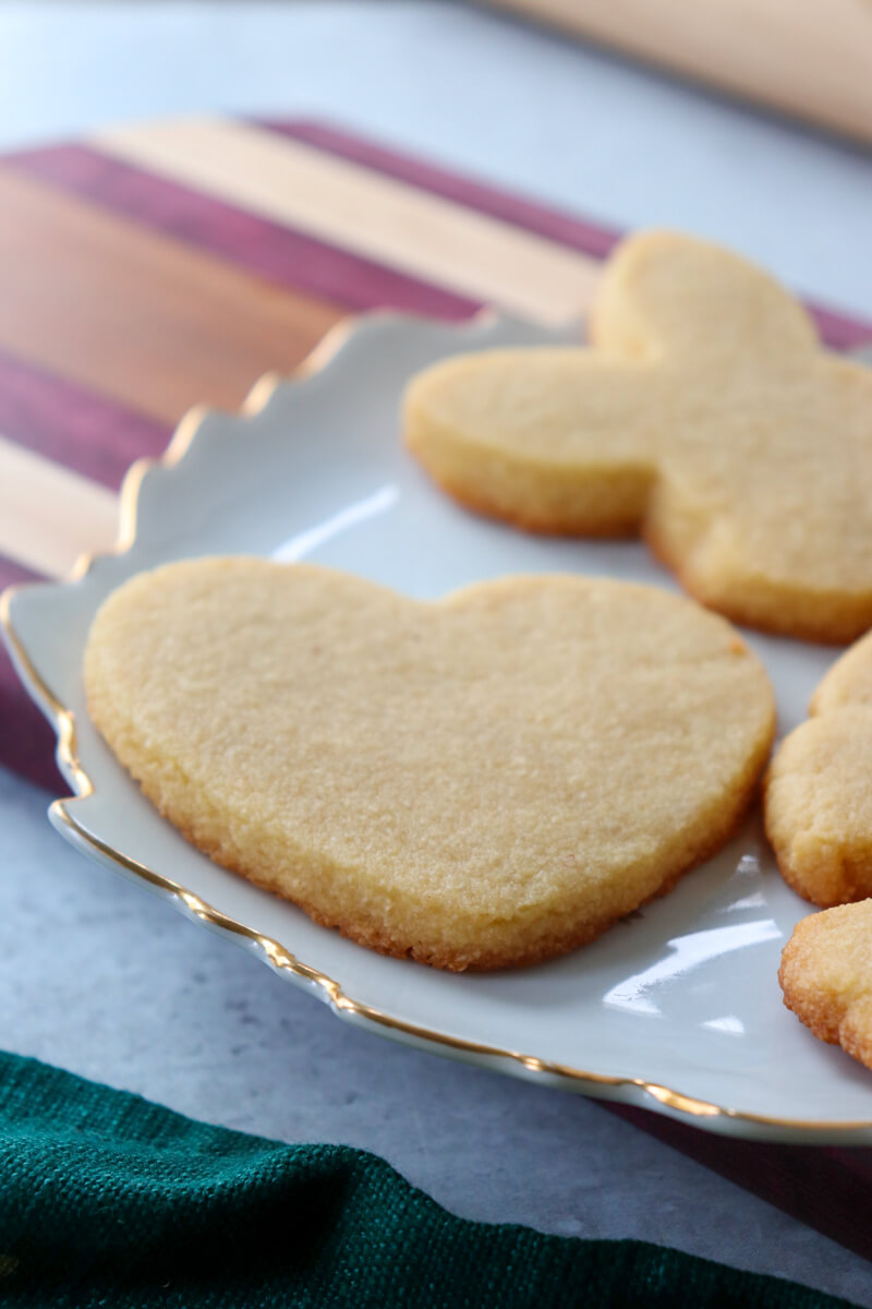 Front view of holiday themed cut out keto short bread cookies on a white plate, heart, rabbit, etc.