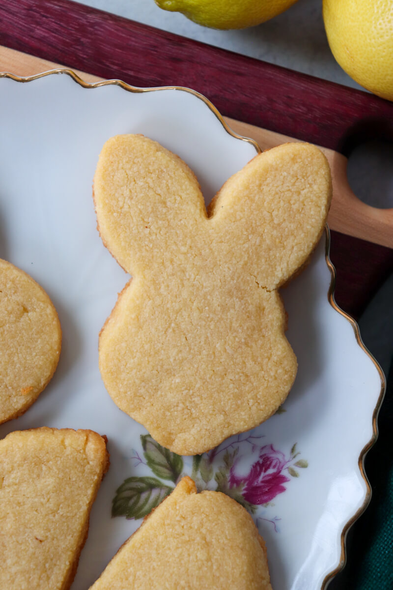 A low carb bunny shaped shortbread cookie on a white plate with others around