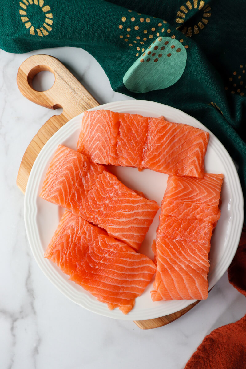 Overhead view of raw salmon on a white plate