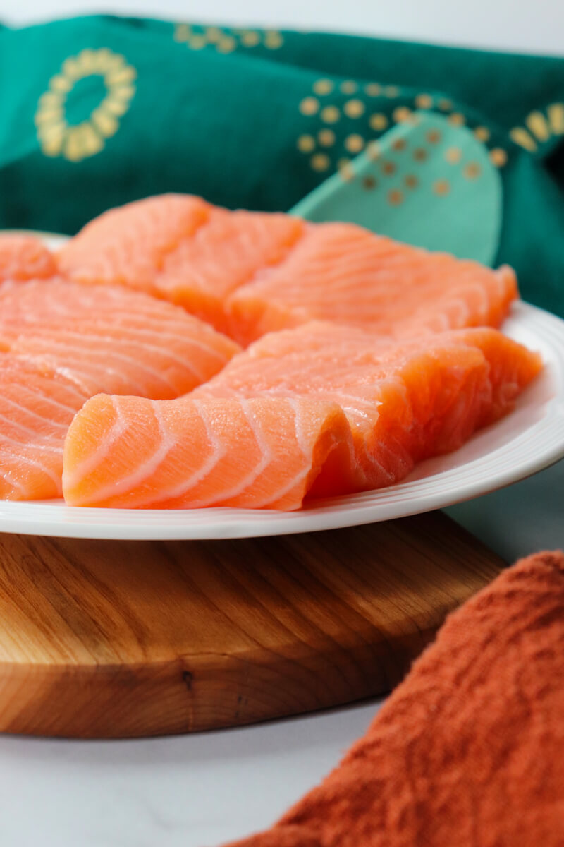 Front close up view of raw salmon on a white plate