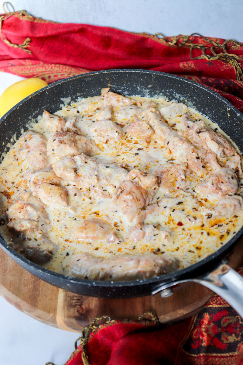 Overhead view of a skillet with creamy lemon garlic chicken in sauce