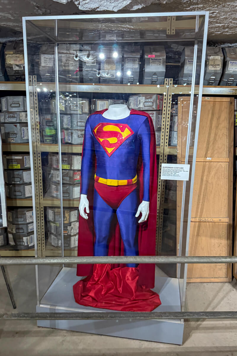 Superman movie costume displayed in underground storage vault at Strataca Salt Mine in Hutchinson Kansas with archival boxes behind glass