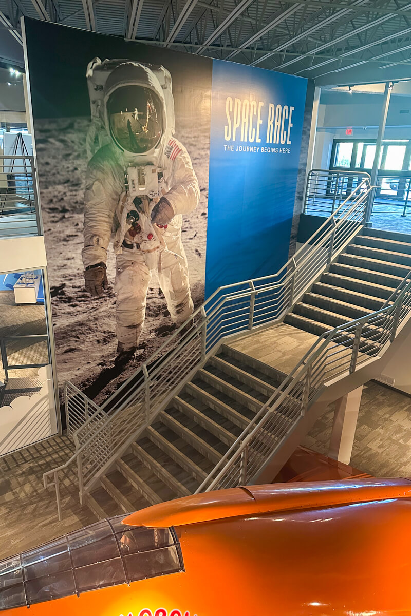 Staircase in front of a large mural of a an astronaut in suit walking on the moon