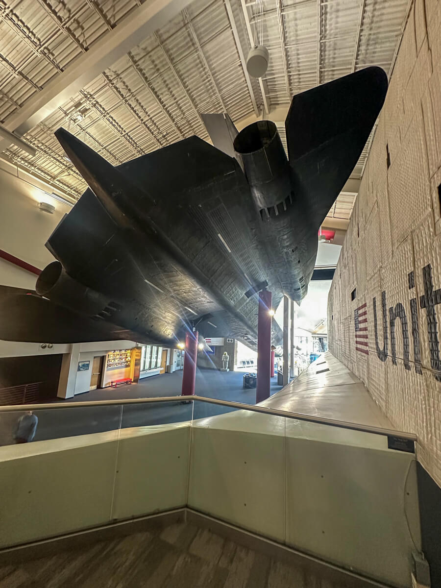 Airplane exhibit view from the inside looking at the side of a white airplane up at a black airplane