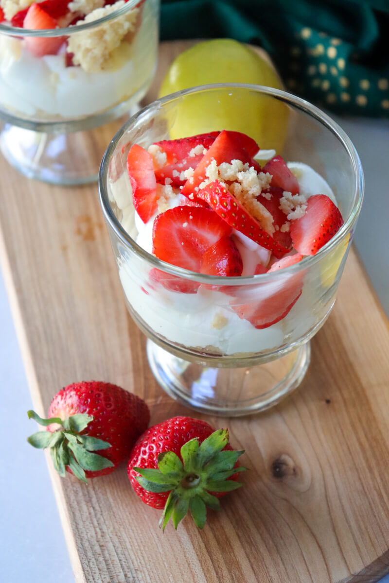 Low-carb no-bake strawberry cheesecake cup layered with creamy cheesecake filling, fresh strawberries, and almond flour crumble topping.