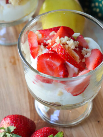 Low-carb no-bake strawberry cheesecake cup layered with creamy cheesecake filling, fresh strawberries, and almond flour crumble topping.